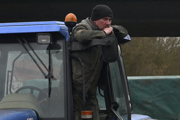 A farmer stands on his tractor as farmers block a highway near Beauvais, northern France. 