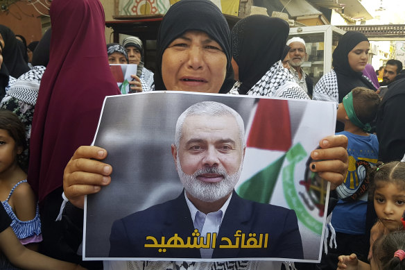 A Hamas supporter holds a poster of its political chief Ismail Haniyeh during a protest to condemn his killing.