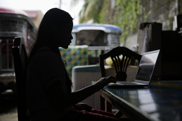 A grade school student uses her laptop at her home in Quezon City in the Philippines as she attends the first day of the new school year last month remotely.