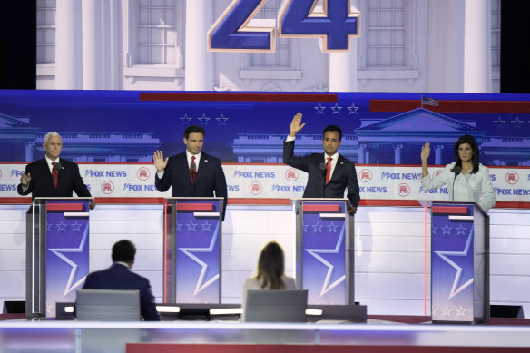 Former vice president Mike Pence (left), Florida Governor Ron DeSantis, businessman Vivek Ramaswamy and former UN ambassador Nikki Haley raise hands in support of Trump at the first Republican debate.