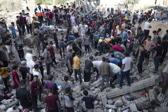 Palestinians look fro survivors after Israeli airstrikes in Khan Younis, Gaza Strip, Monday, October 16.