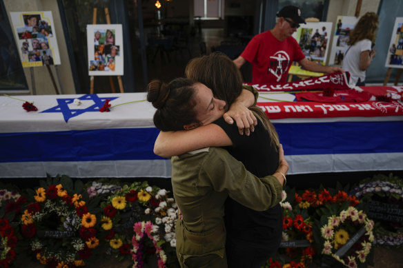 Mourners embrace during the funeral of Meni and Ayelet Godard, in Kibbutz Palmachim, Israel, on October 29.  The Israeli couple were killed by Hamas militants in Kibbutz Be’eri near the border with the Gaza Strip.