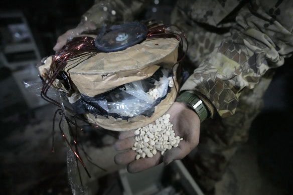 A Syrian rebel shows captagon pills hidden inside a machine part.