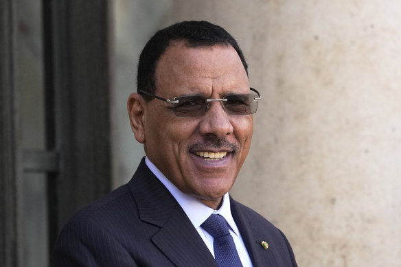 Niger President Mohamed Bazoum smiles before a working lunch with French President Emmanuel Macron in Paris in February. He’s reportedly detained at the presidential palace surviving on military rations.