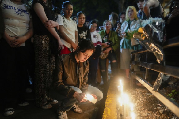 Fans light candles outside the hotel where Payne fell to his death. 