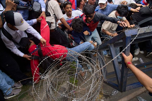 A protester falls down during clashes with riot police in Kathmandu.
