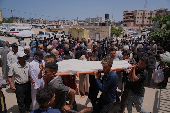 Palestinians carry the body of a person killed while heading to a Gaza aid hub, during a funeral at the Nasser Hospital in Khan Younis on Sunday.