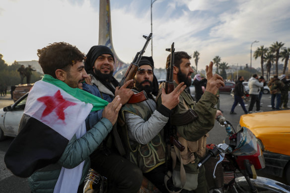 Syrian opposition fighters celebrate after the government collapsed in Damascus on Sunday.