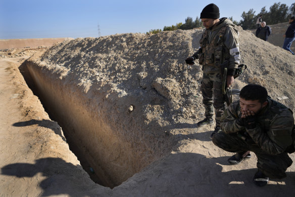 Syrian rebels observe a location identified as a mass grave for detainees killed under the rule of Bashar al-Assad in Najha, south of Damascus.