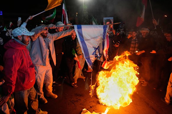 Manifestantes pró-governo iranianos em Teerã queimam bandeiras dos EUA e de Israel após o anúncio de um cessar-fogo de duas semanas na guerra com os Estados Unidos e Israel. 