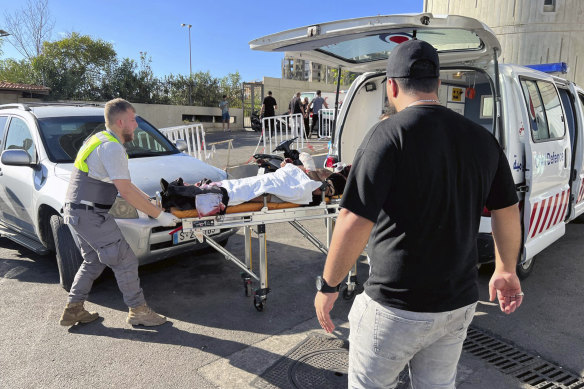 Civil Defence first-responders carry a wounded man whose handheld pager exploded.