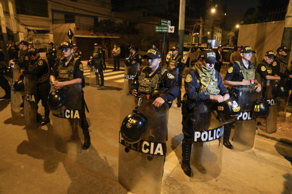 Police guard outside President Dina Boluarte’s house during a raid ordered by the attorney-general’s Office.