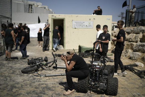 A woman from the Druze minority weeps near the site where 12 children and teens were killed in a rocket strike on a soccer field.