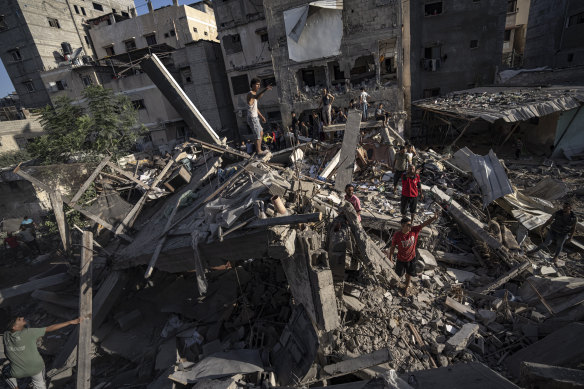 Palestinians look at the destruction after Israeli strikes on the Gaza Strip in Khan Younis.