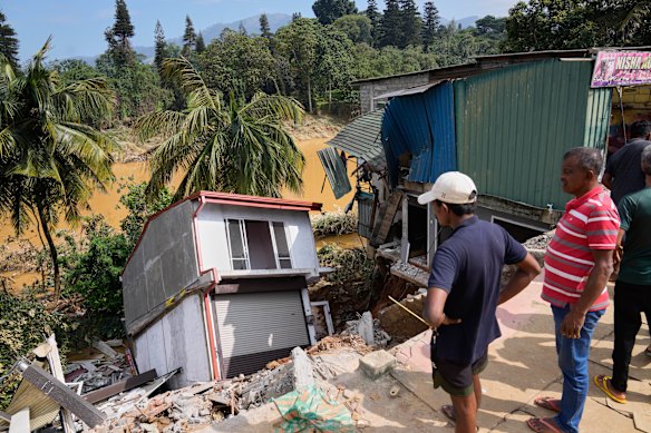 People look at a building damaged by the floods in Peradeniya, Sri Lanka, on Monday.
