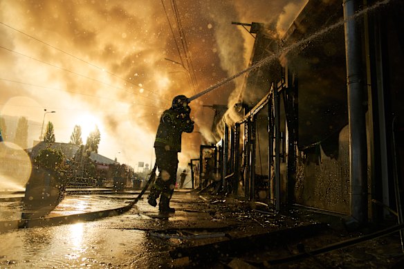 Firefighters try to extinguish the fire consuming Kyiv’s book market following a Russian missile attack.