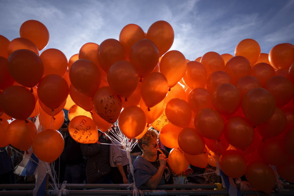 Demonstrators hold orange balloons at a Tel aviv rally in solidarity with Kfir Bibas, an Israeli boy who spent his first birthday, on Thursday, in Hamas captivity in the Gaza Strip.