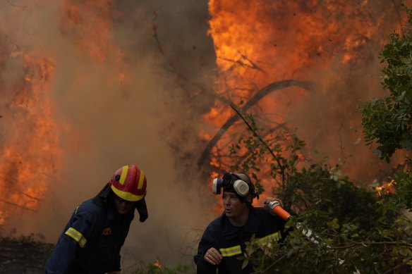 Firefighters battle blazes in Greece on Monday, during heatwaves exacerbated by extreme heat.