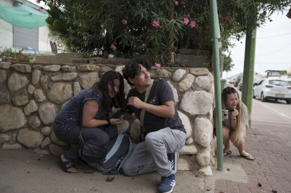 Israelis take cover from the incoming rocket fire from the Gaza Strip in Ashkelon, southern Israel.