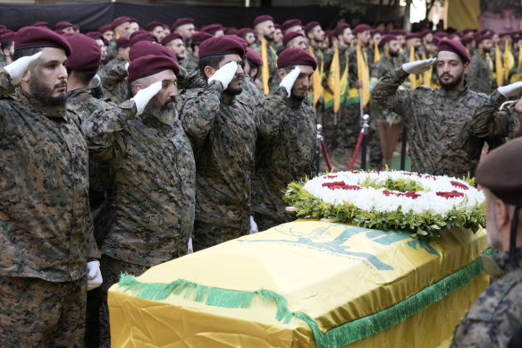 Hezbollah members salute near the coffin of Hezbollah commander Ibrahim Akil.