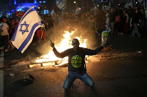 A protester holds an Israeli flag in Tel Aviv.