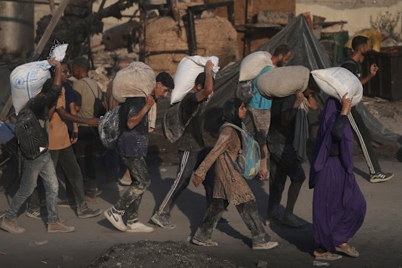 Palestinians carry sacks of flour unloaded from a humanitarian aid convoy that reached Gaza City from the northern Gaza Strip on Saturday.