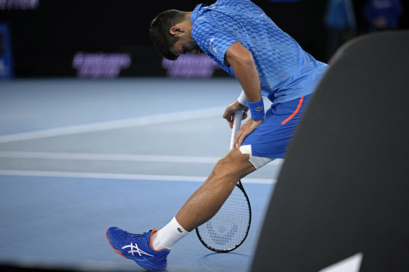 Novak Djokovic stretches his leg during a break.