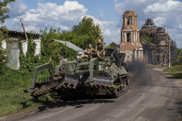 Ukrainian servicemen ride atop on armoured vehicle at the Russian-Ukrainian border in Sumy region, Ukraine.