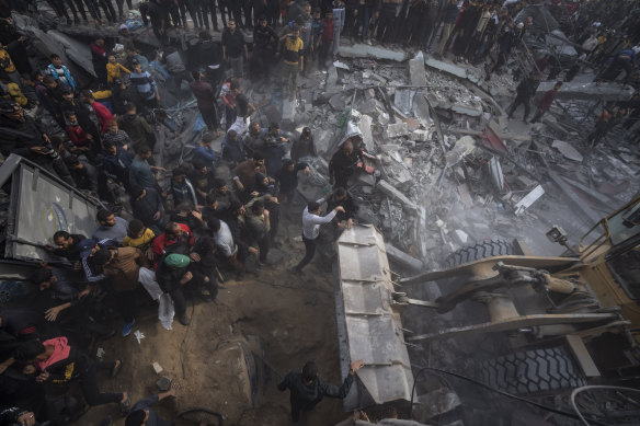 Palestinians search for bodies and survivors in the rubble of a residential building destroyed in an Israeli airstrike, in Rafah, on Wednesday.