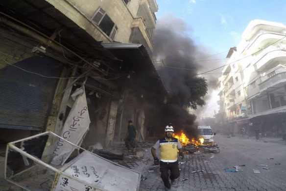 A White Helmet civil defence worker runs at the site where a shell struck in the outskirts of the northern town of Jisr al-Shoughour, west of the city of Idlib, Syria, on Thursday.