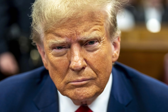 Former president Donald Trump sits in a courtroom in Manhattan criminal court.