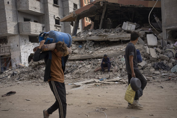 Palestinians walk through the destruction after Israeli troops pulled out of Khan Younis.