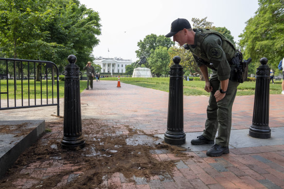 Bir ABD Park Polisi, Beyaz Saray yakınlarındaki Lafayette Square parkındaki bir güvenlik bariyerini hasar açısından inceliyor.