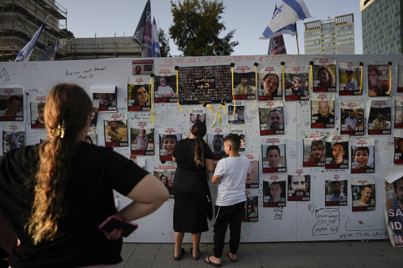 People look at photographs of hostages, mostly Israeli civilians, who were abducted on October 7 by Hamas.