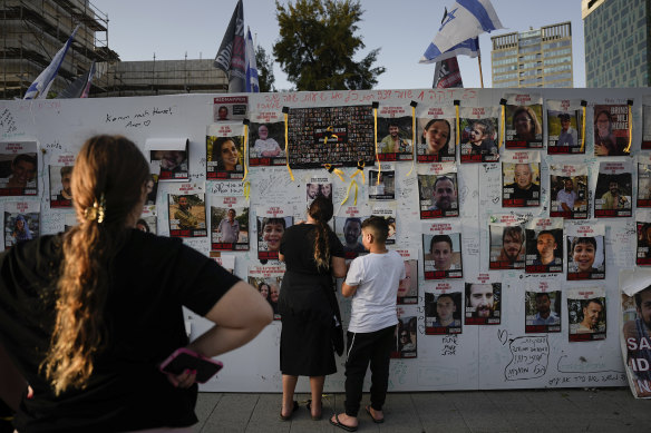 People in Tel Aviv look at posters of hostages who were abducted on October 7 by Hamas.