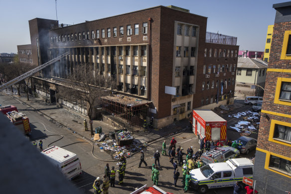 Paramedics and emergency workers work at the scene of a deadly fire in downtown Johannesburg on August 31.
