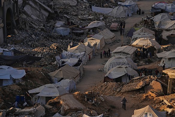 A tent camp for displaced Palestinians stretches among the ruins of buildings destroyed by Israeli bombardments west of the Gaza city.
