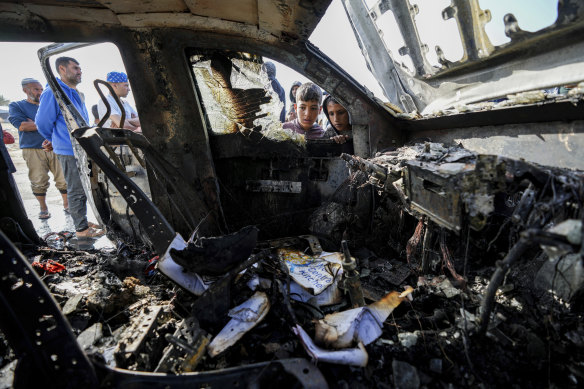 People inspect the site where World Central Kitchen workers were killed in Deir al-Balah.