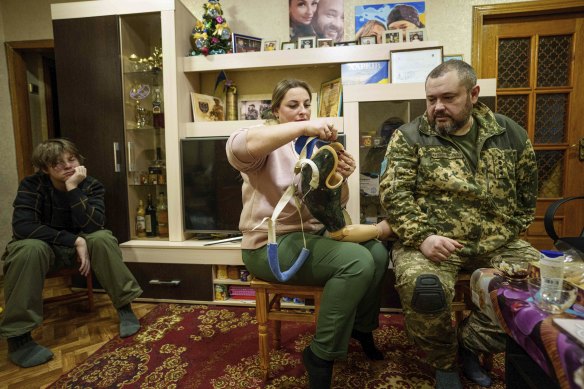 Oleksandr Puzikov, a captain with Ukraine’s 127th brigade who lost an arm in combat, and his wife, Iryna, look at an arm prosthesis in their apartment in Kharkiv, Ukraine.