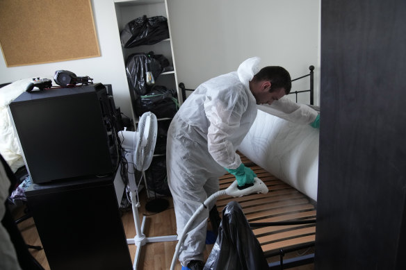 Pest control technician Lucas Pradalier sprays steam on a bed in a Paris apartment.