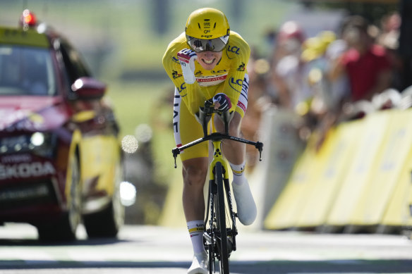 Slovenia’s Tadej Pogacar, wearing the overall leader’s yellow jersey, celebrates as he crosses the finish line of the twentieth stage of the Tour de France.