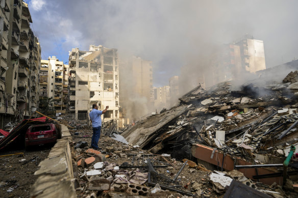 A man documents destroyed buildings at the site of an Israeli airstrike in a Beirut’s southern suburb, Lebanon, on Tuesday.