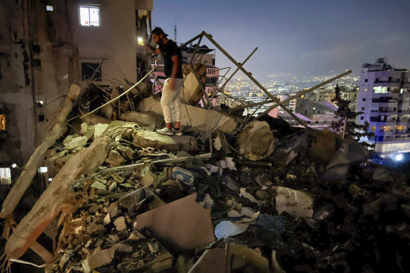 A man inspects a destroyed building that was hit by an Israeli airstrike.