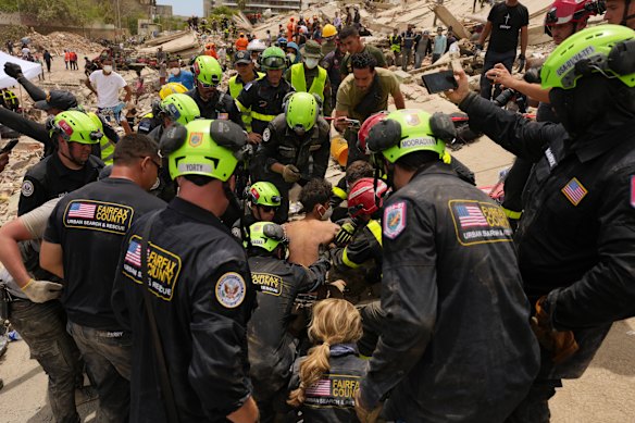 I soccorritori americani tirano fuori un ragazzo dalle macerie a La Guaira quattro giorni dopo il devastante terremoto.