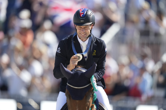 Australia’s Christopher Burton, riding Shadow Man, celebrates his silver medal.