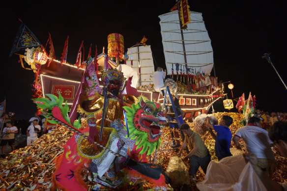 Ethnic Chinese devotees prepare a Wangkang ship during night culminating in a send-off ceremony.