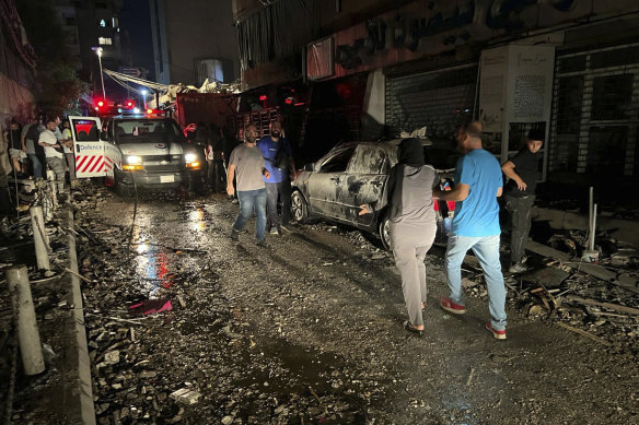 People walk near the building that was hit by an Israeli airstrike in the southern suburbs of Beirut, Lebanon, on Tuesday.