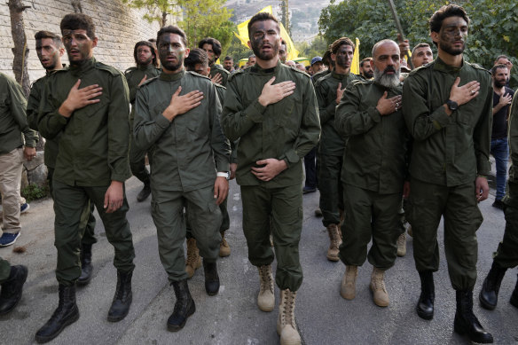 Hezbollah fighters mourn, as they attend the funeral procession of their two comrades who were killed by Israeli shelling, in Kherbet Selem village, south Lebanon on Tuesday.