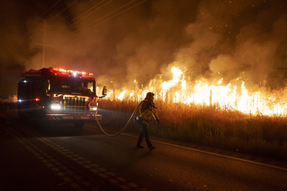 A firefighter watches flames approach Gilman Springs Road during the Rabbit Fire late on Friday, 
in Moreno Valley, California.