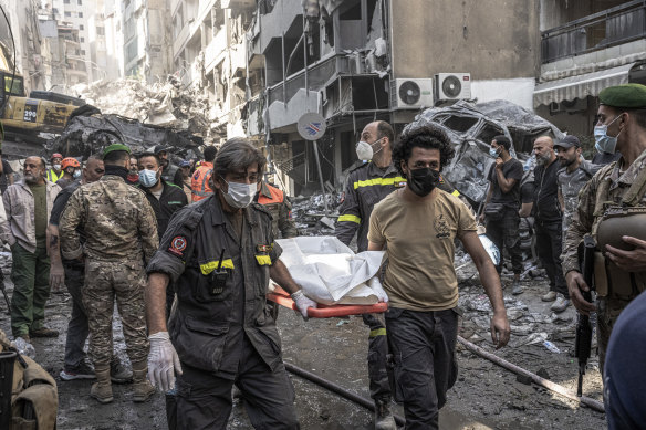 Civil defence workers carry a body found under rubble after an Israeli airstrike in Beirut.